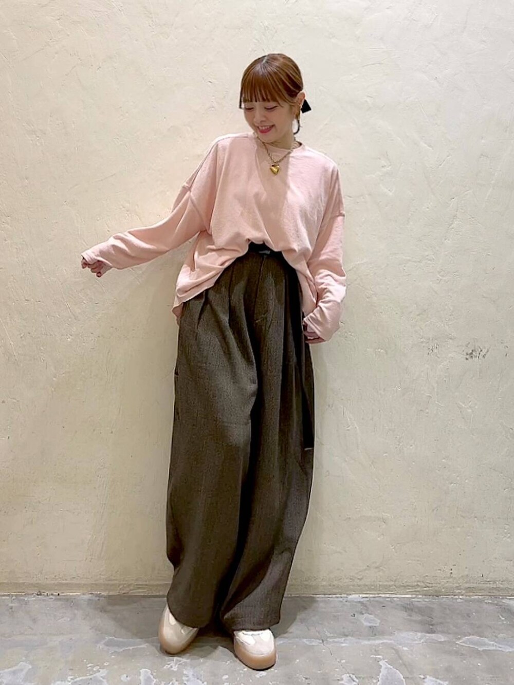 ブラウン系のその他パンツ、ピンク系のTシャツ/カットソー、イエロー系のリングを着用したレディースの冬コーディネートの9枚目の写真