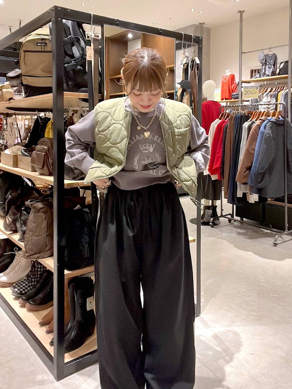 グリーン系のベスト、グレー系のTシャツ/カットソーを着用したレディースの秋コーディネートの4枚目の写真