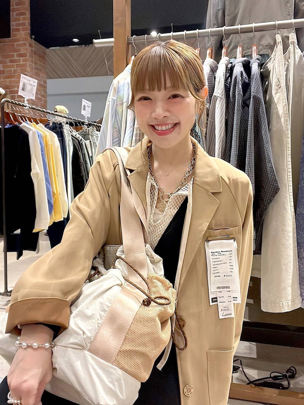 ベージュ系のトートバッグ、ブラック系のサロペット/オーバーオール、ホワイト系のTシャツ/カットソーを着用したレディースの冬コーディネートの4枚目の写真