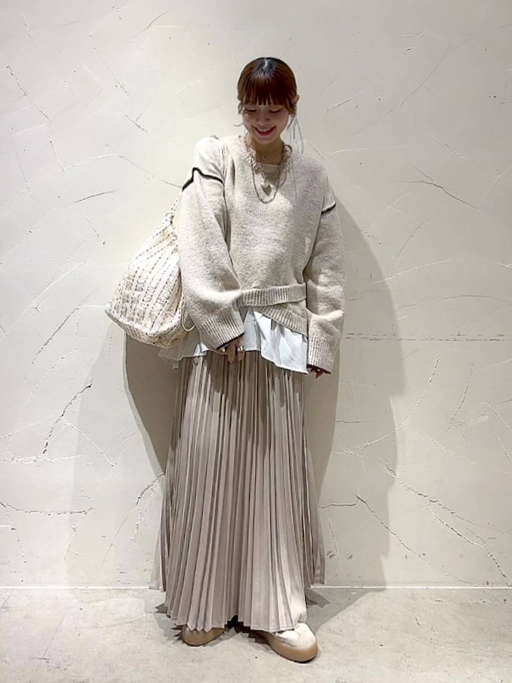 ベージュ系のスカート、その他のトートバッグ、ゴールド系のネックレスを着用したレディースの秋コーディネートの7枚目の写真