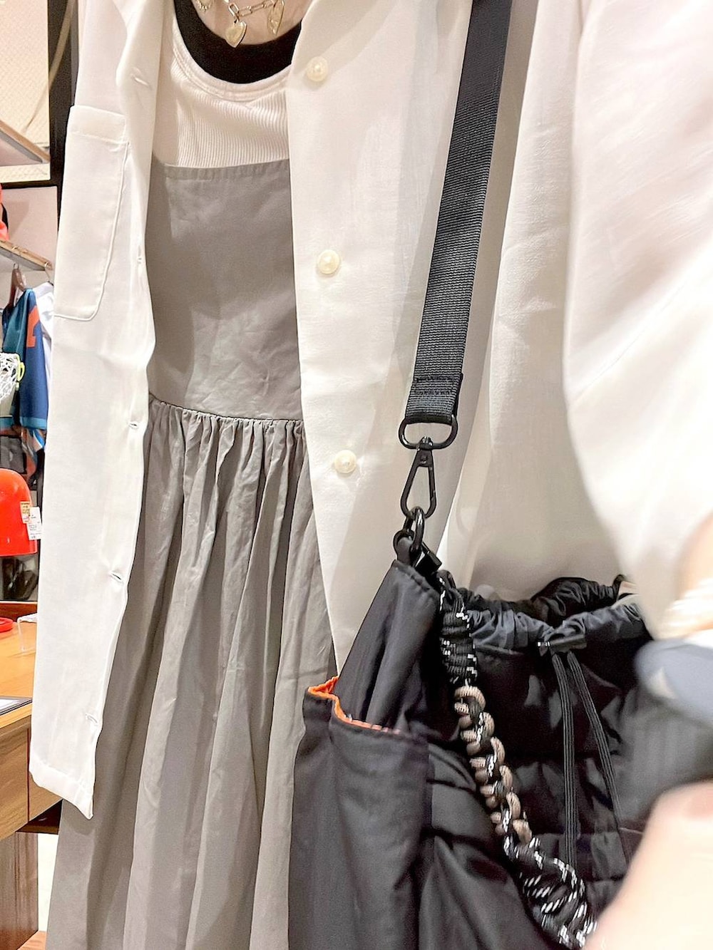 ベージュ系のシャツ/ブラウス、ブラック系のショルダーバッグ、ホワイト系のタンクトップを着用したレディースの夏コーディネートの5枚目の写真
