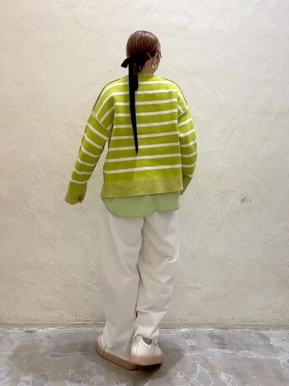 ホワイト系のその他パンツ、シルバー系のショルダーバッグ、イエロー系のニット/セーターを着用したレディースの冬コーディネートの5枚目の写真