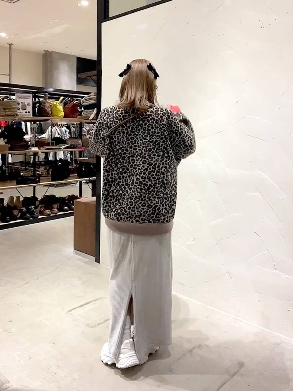 レッド系のTシャツ/カットソー、グレー系のスカート、ベージュ系のスニーカーを着用したレディースの冬コーディネートの8枚目の写真