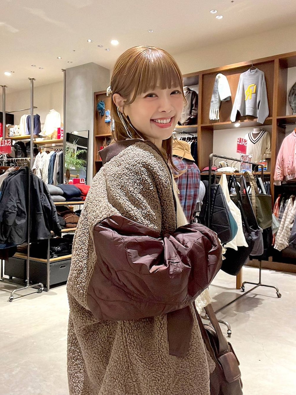 ホワイト系のTシャツ/カットソー、レッド系のMA-1、ブラウン系のスカートを着用したレディースの冬コーディネートの3枚目の写真