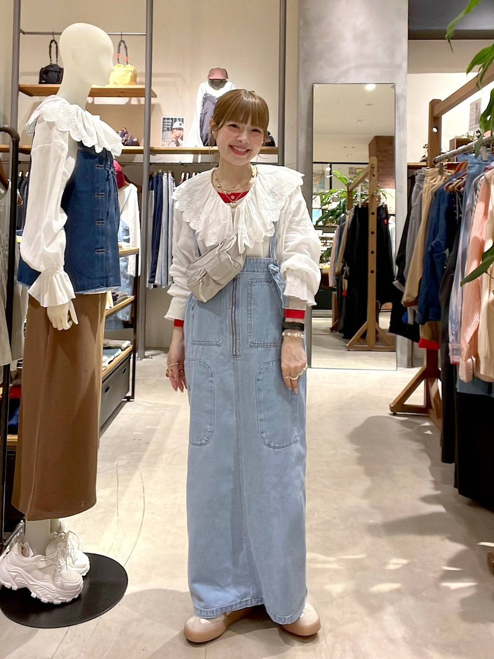 ブルー系のジャンパースカート、ベージュ系のTシャツ/カットソー、ホワイト系のシャツ/ブラウスを着用したレディースの冬コーディネートの3枚目の写真