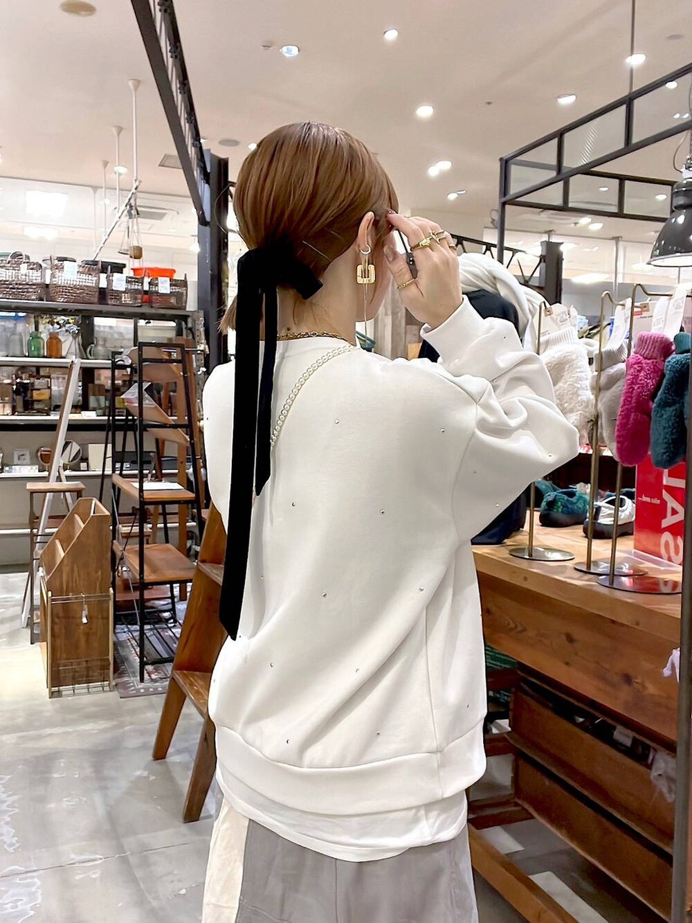 ゴールド系のショルダーバッグ、ホワイト系のTシャツ/カットソー、ホワイト系のその他トップスを着用したレディースの冬コーディネートの7枚目の写真