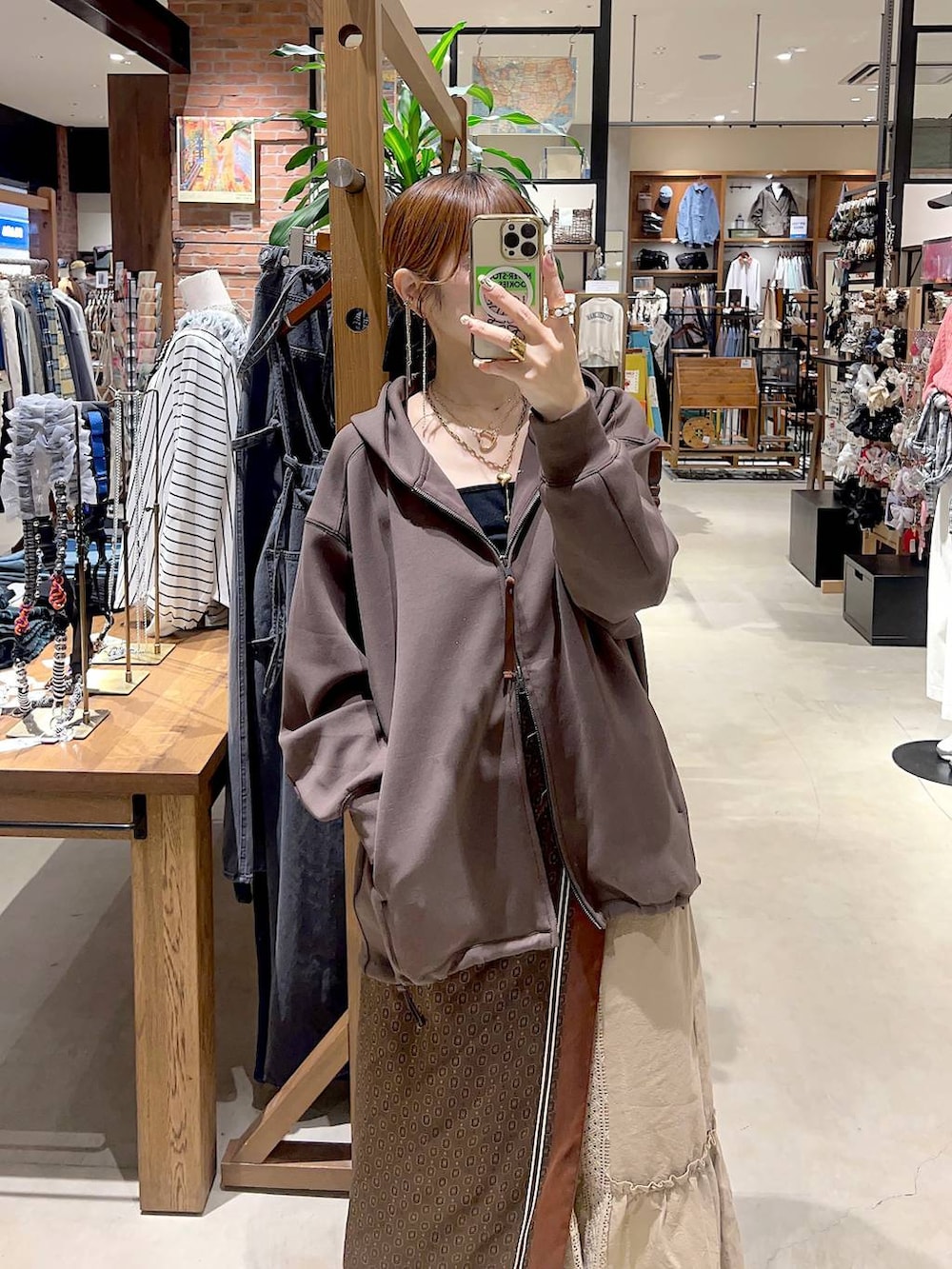 イエロー系のスカート、ブラウン系のパーカー、ベージュ系のボストンバッグを着用したレディースの秋コーディネートの7枚目の写真