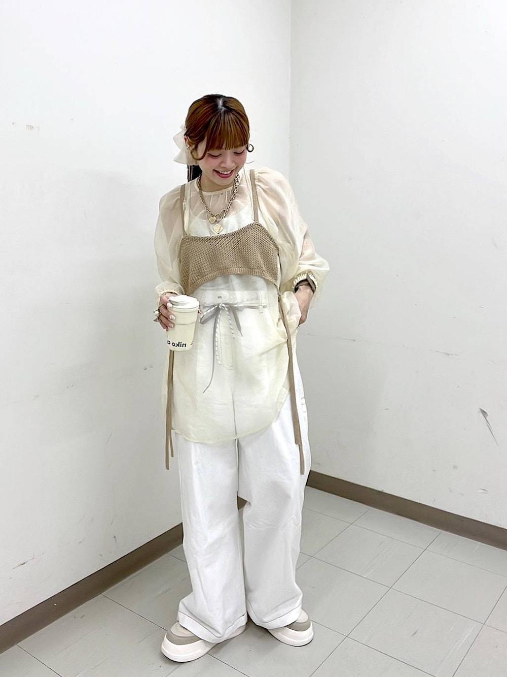 ベージュ系のスニーカー、ゴールド系のリング、グリーン系のアナログ腕時計を着用したレディースの春コーディネートの4枚目の写真