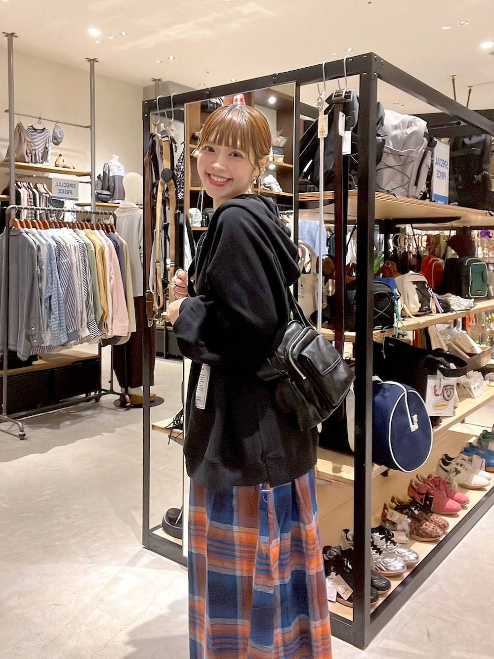 ブラック系のショルダーバッグ、イエロー系のネックレスを着用したレディースの秋コーディネートの7枚目の写真