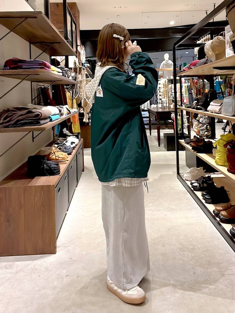 グレー系のスカート、ベージュ系のシャツ/ブラウス、グリーン系のナイロンジャケットを着用したレディースの冬コーディネートの6枚目の写真