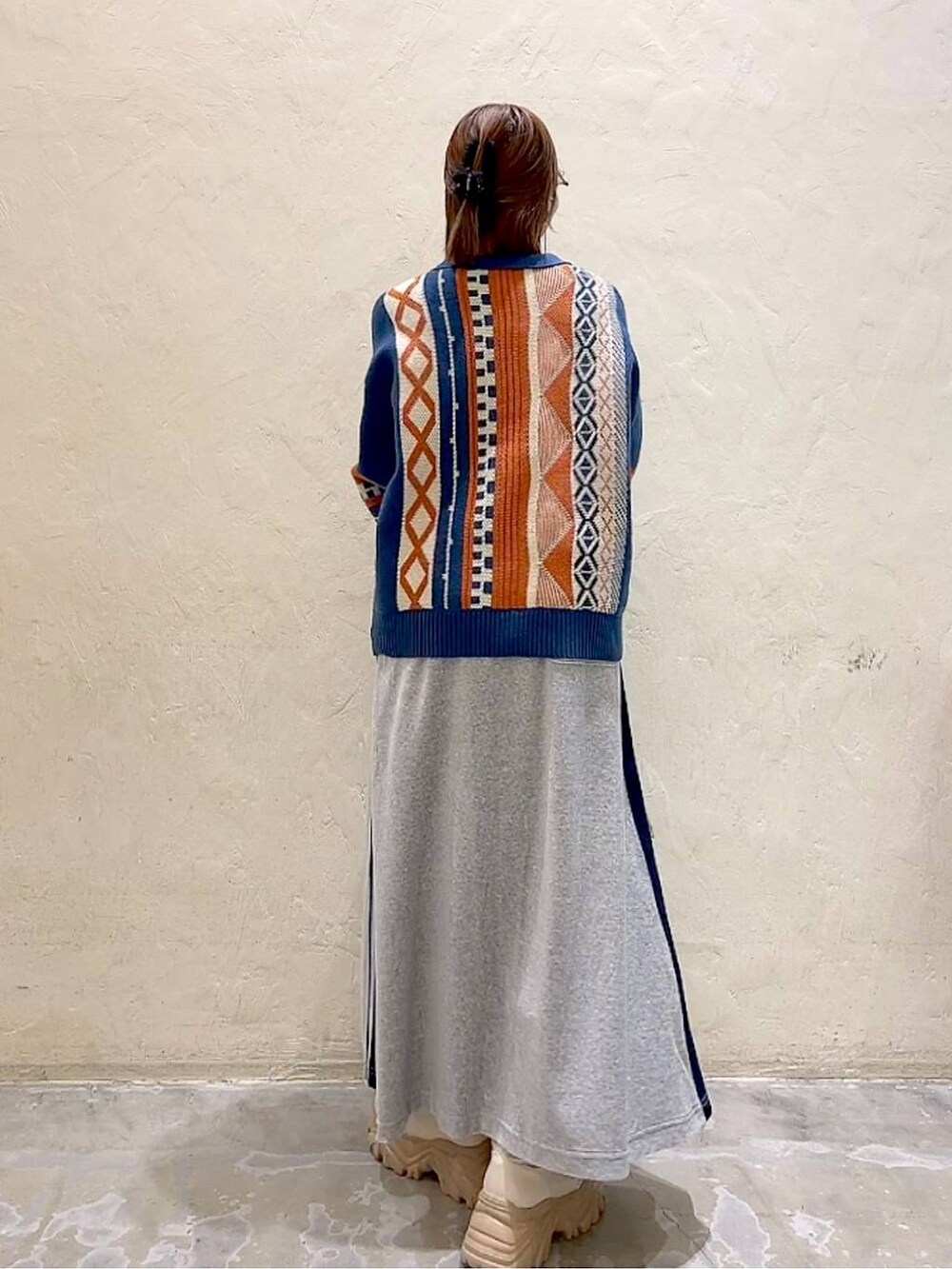 ブルー系のニット/セーター、グレー系のストール/ショール、ブラック系のバレッタ/ヘアクリップを着用したレディースの秋コーディネートの6枚目の写真