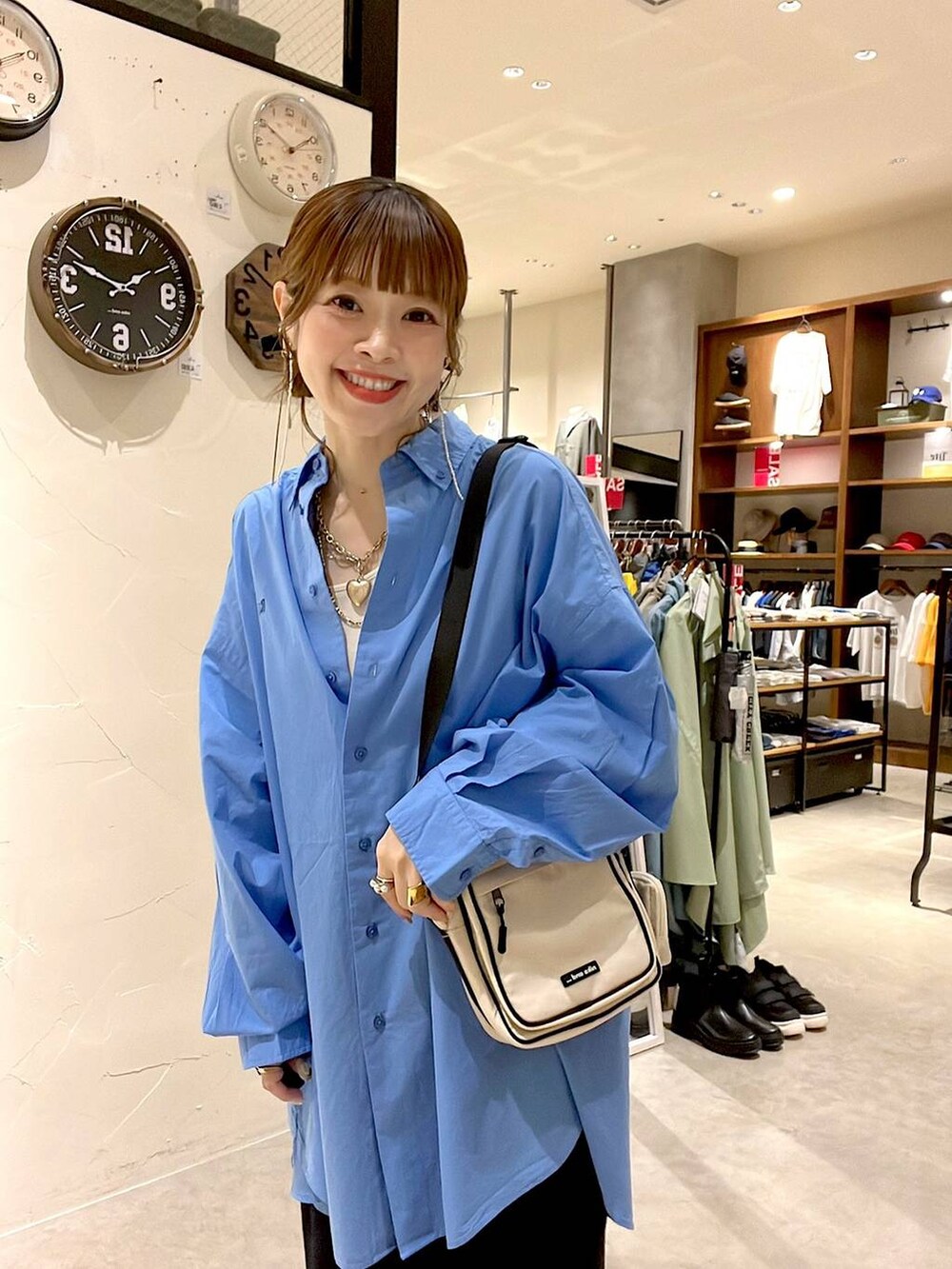 ブラック系のスカート、ブルー系のシャツ/ブラウス、ベージュ系のショルダーバッグを着用したレディースの夏コーディネートの7枚目の写真