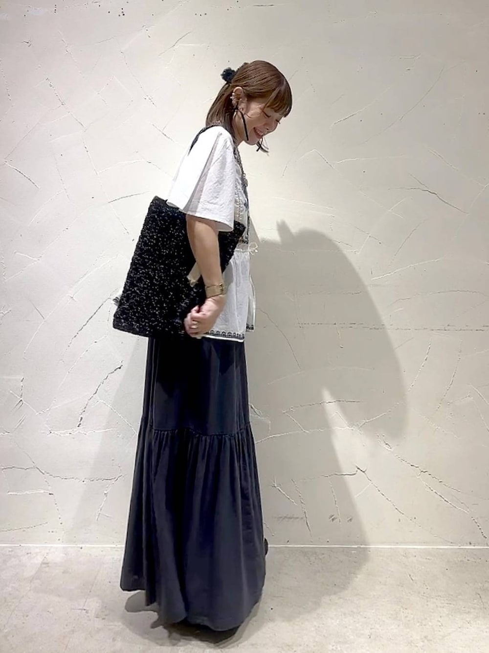 グレー系のスカート、ホワイト系のシャツ/ブラウス、ブラック系のトートバッグを着用したレディースの春コーディネートの5枚目の写真
