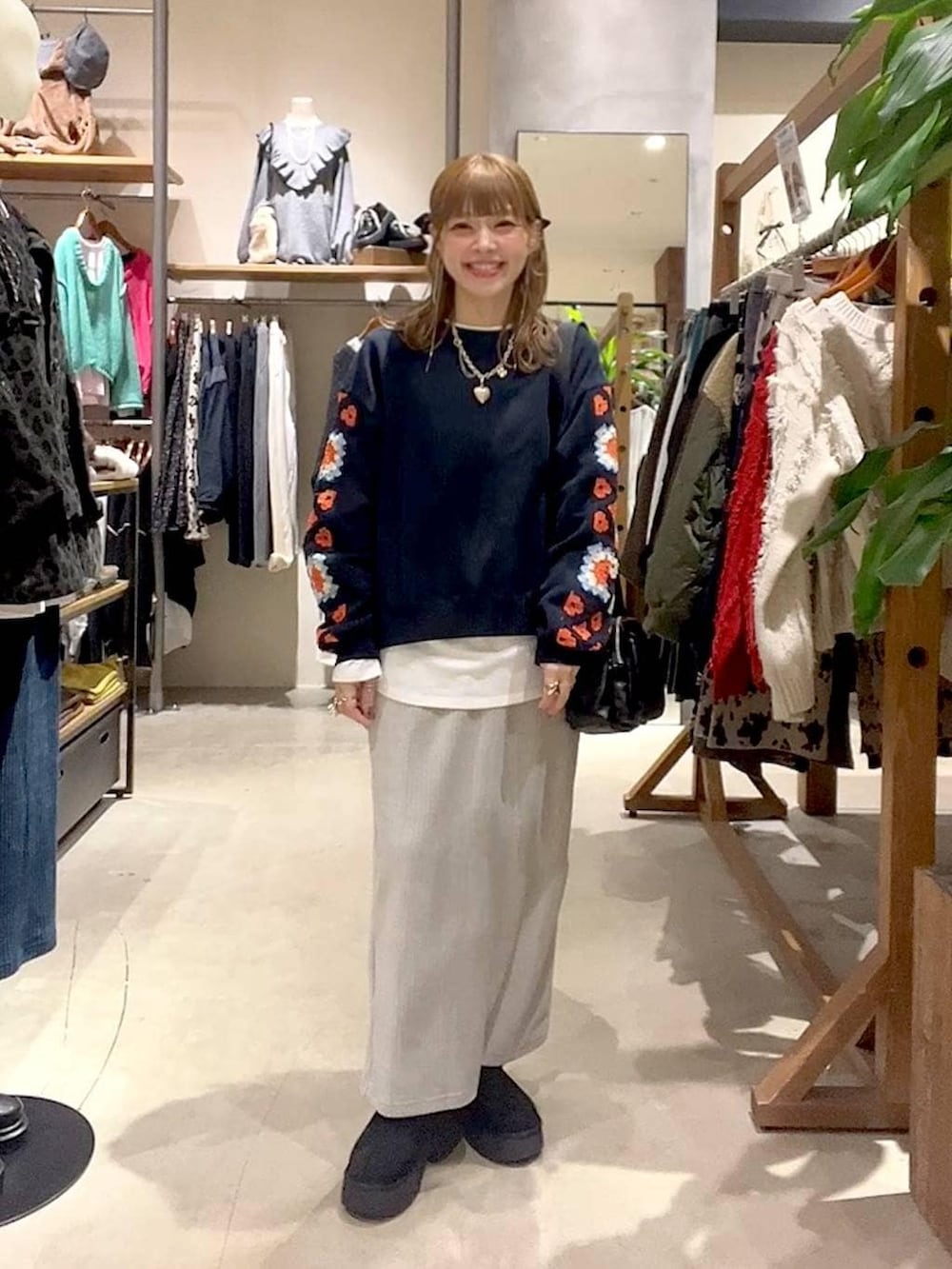 ブルー系のスウェット、ホワイト系のTシャツ/カットソー、グレー系のスカートを着用したレディースの冬コーディネートの6枚目の写真