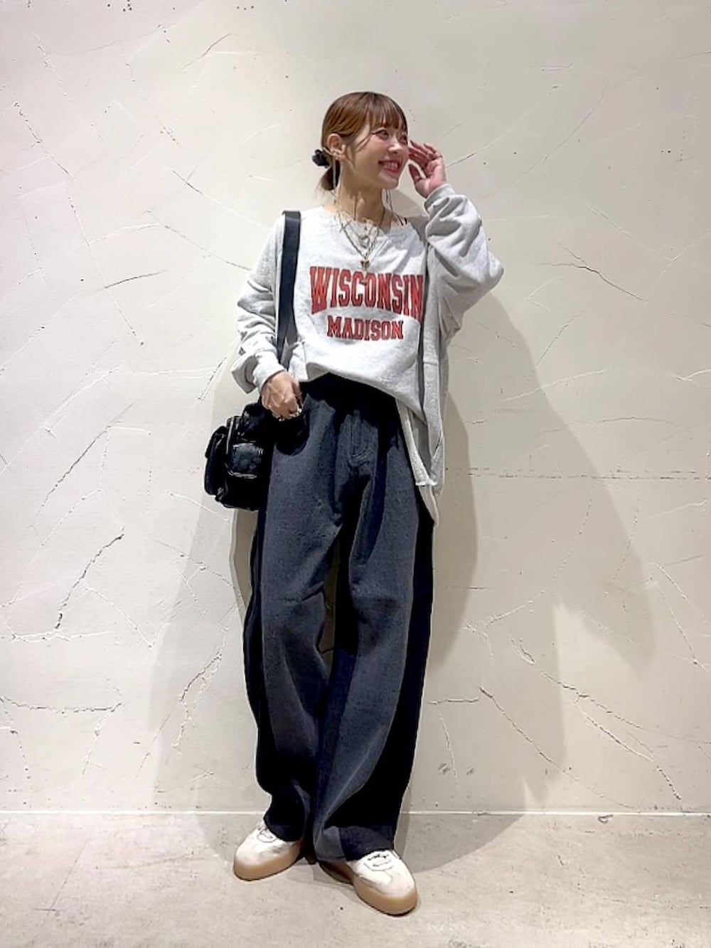 ベージュ系のスウェット、ブラック系のショルダーバッグ、イエロー系のネックレスを着用したレディースの秋コーディネートの4枚目の写真