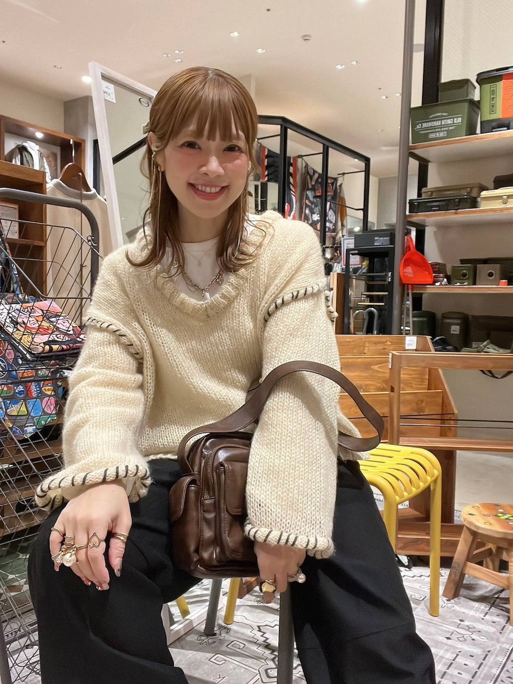 ホワイト系のTシャツ/カットソー、ブラウン系のショルダーバッグ、ベージュ系のスニーカーを着用したレディースの冬コーディネートの2枚目の写真