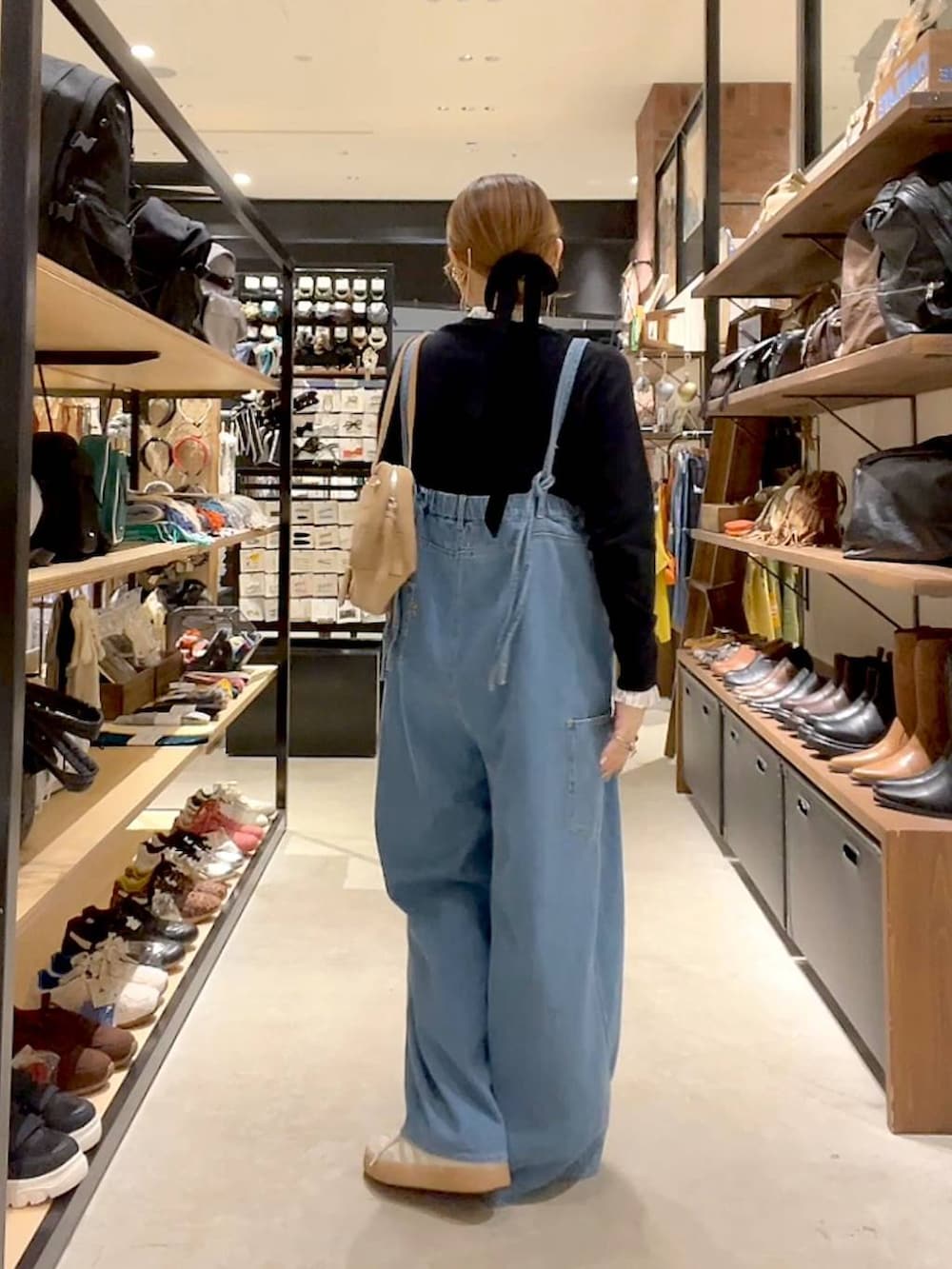 ブラック系のカーディガン/ボレロ、ベージュ系のボストンバッグを着用したレディースの秋コーディネートの4枚目の写真