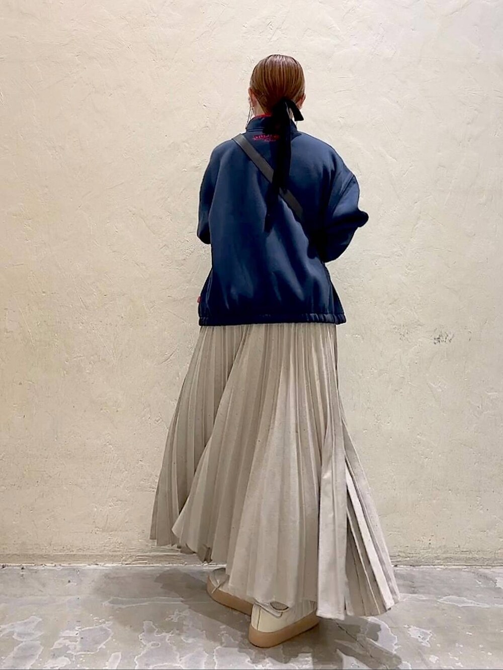 ブルー系のスウェット、ブラック系のショルダーバッグ、グレー系のスカートを着用したレディースの冬コーディネートの4枚目の写真