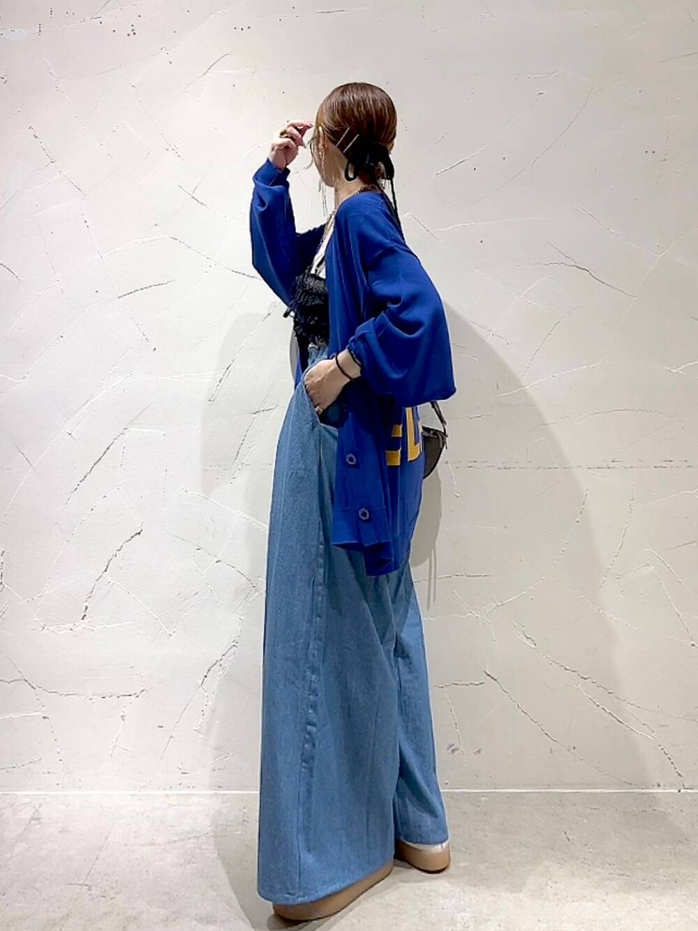 ブラック系のキャミソール、ブラウン系のショルダーバッグを着用したレディースの秋コーディネートの5枚目の写真