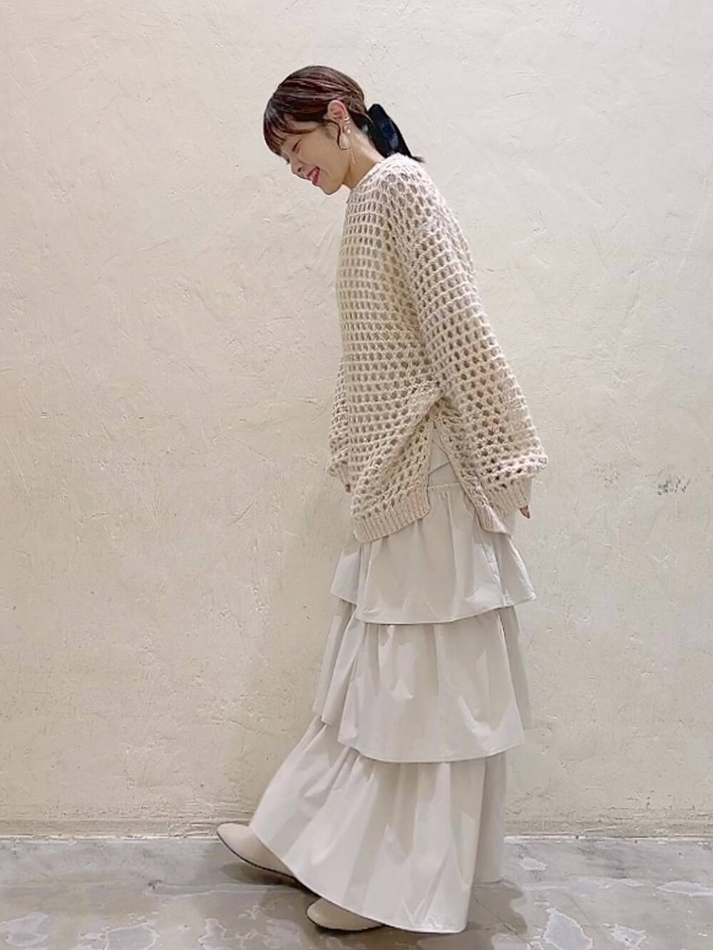 ホワイト系のパンプス、ベージュ系のニット/セーター、ベージュ系のスカートを着用したレディースの冬コーディネートの3枚目の写真