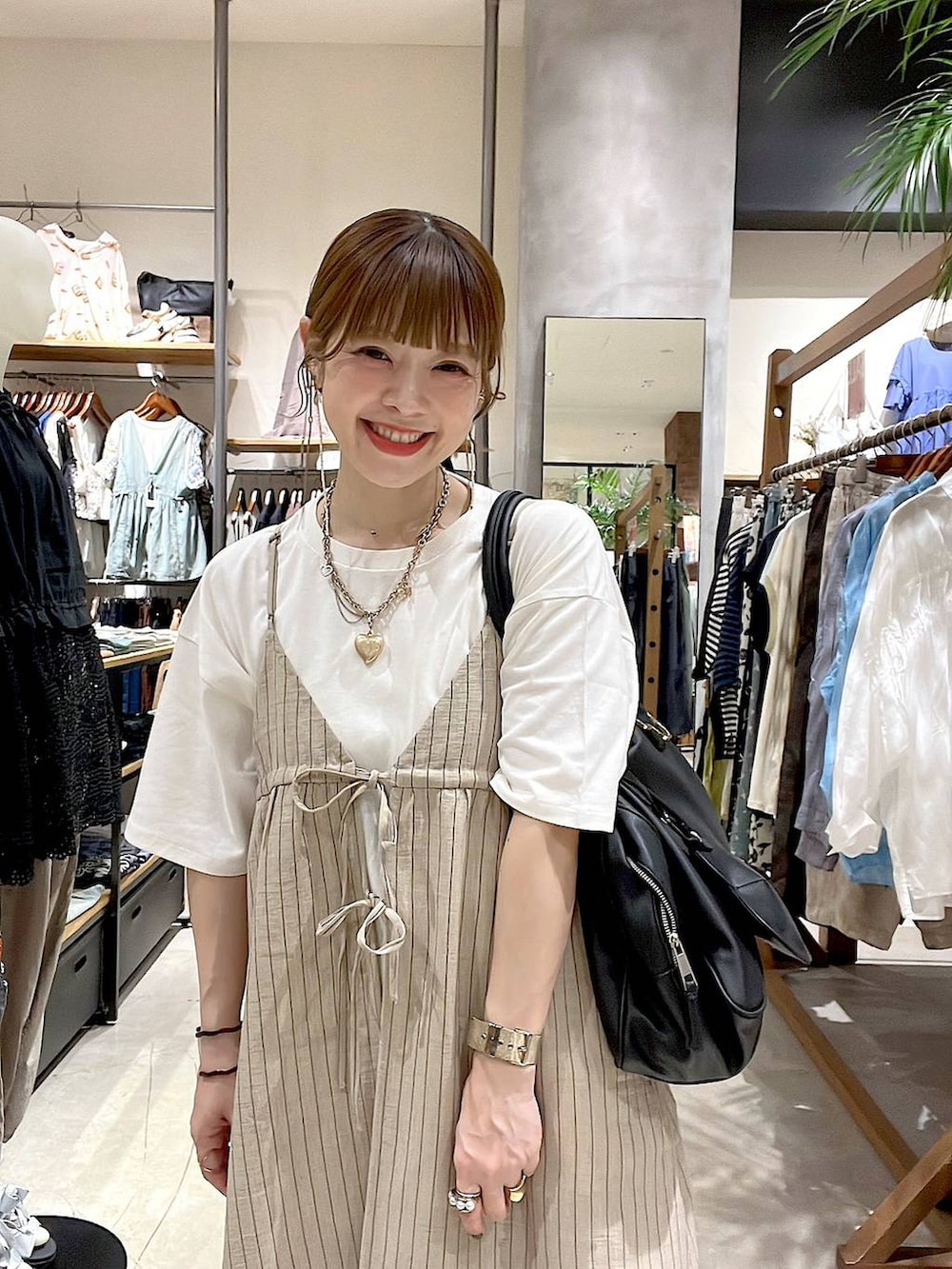 ブラック系のショルダーバッグ、ホワイト系のTシャツ/カットソー、ベージュ系のその他雑貨を着用したレディースの夏コーディネートの8枚目の写真