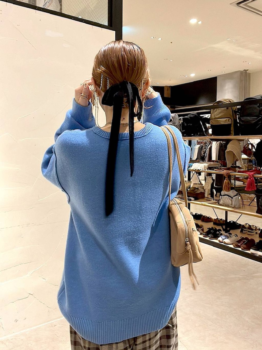 ブラウン系のその他パンツ、ブルー系のニット/セーター、ベージュ系のボストンバッグを着用したレディースの秋コーディネートの7枚目の写真