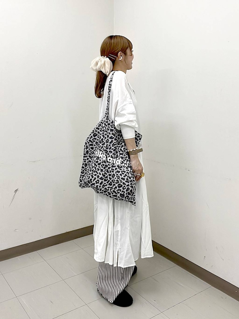 その他のトートバッグ、ブラック系のパンプス、ホワイト系のデニムパンツを着用したレディースの冬コーディネートの3枚目の写真