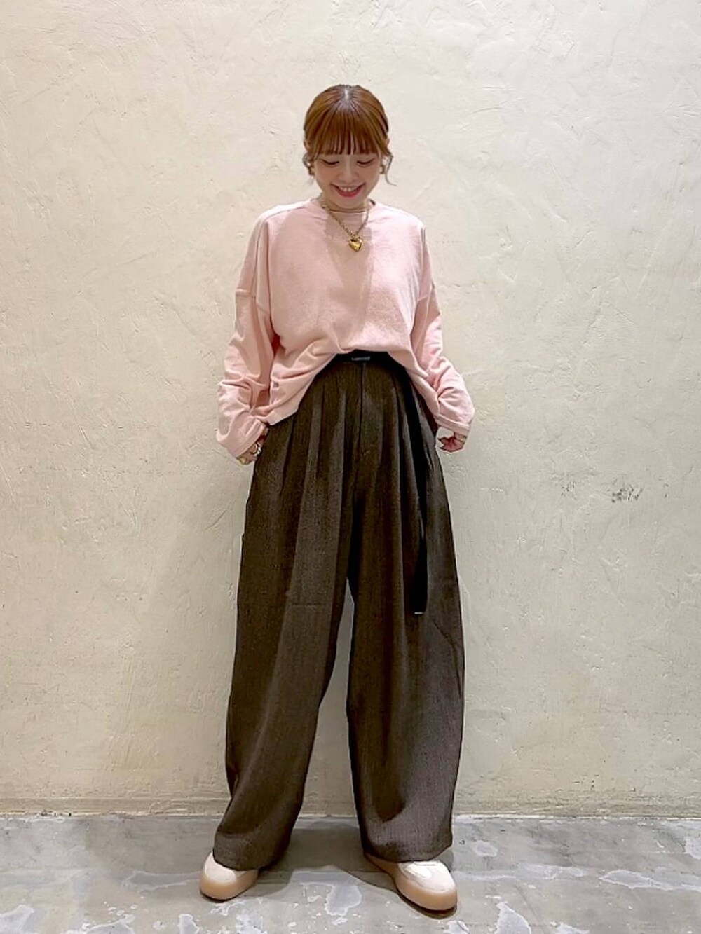 ブラウン系のその他パンツ、ピンク系のTシャツ/カットソー、イエロー系のリングを着用したレディースの冬コーディネートの3枚目の写真