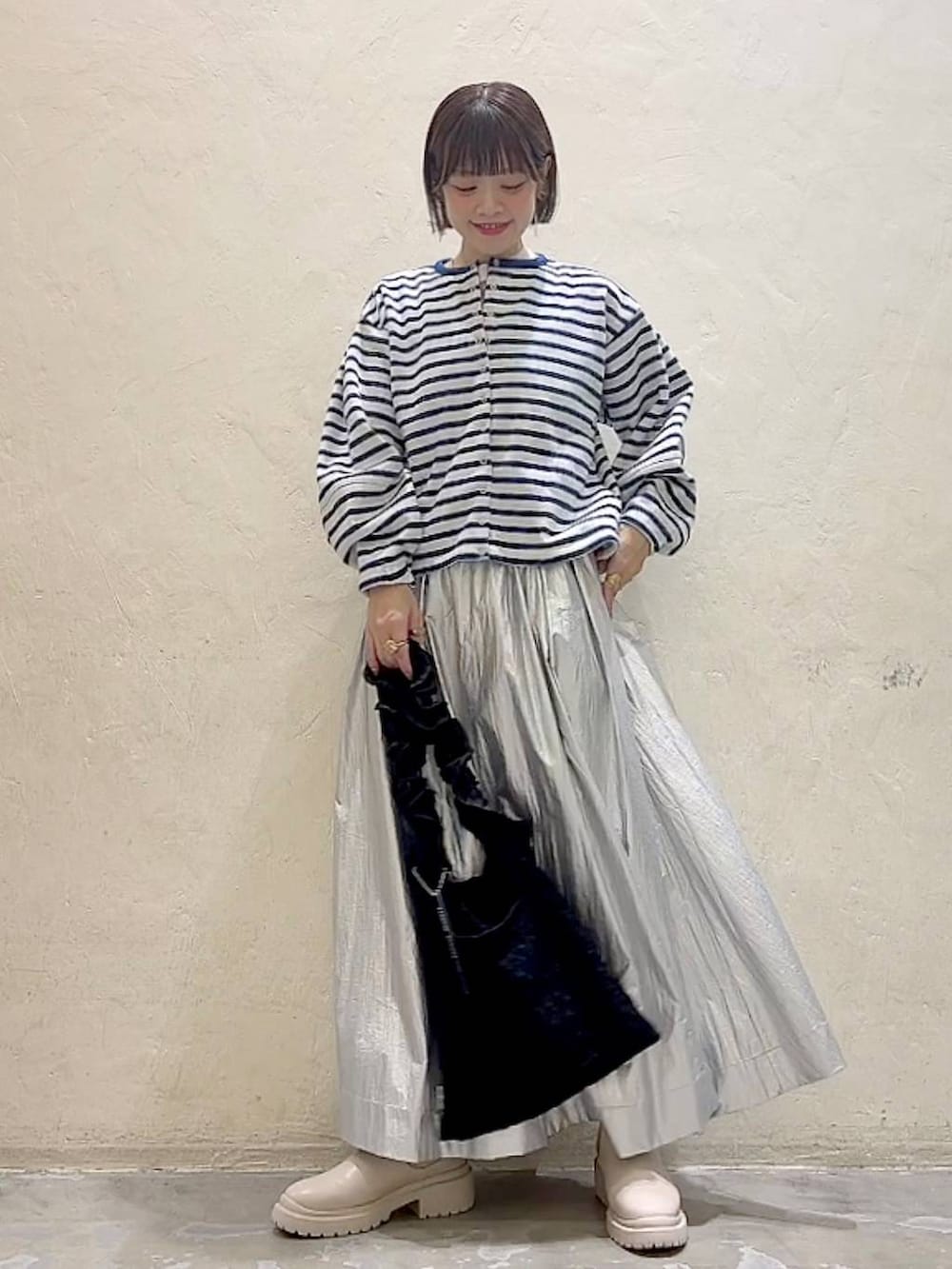 ベージュ系のブーツ、ブラック系のトートバッグ、ホワイト系のTシャツ/カットソーを着用したレディースの冬コーディネートの6枚目の写真