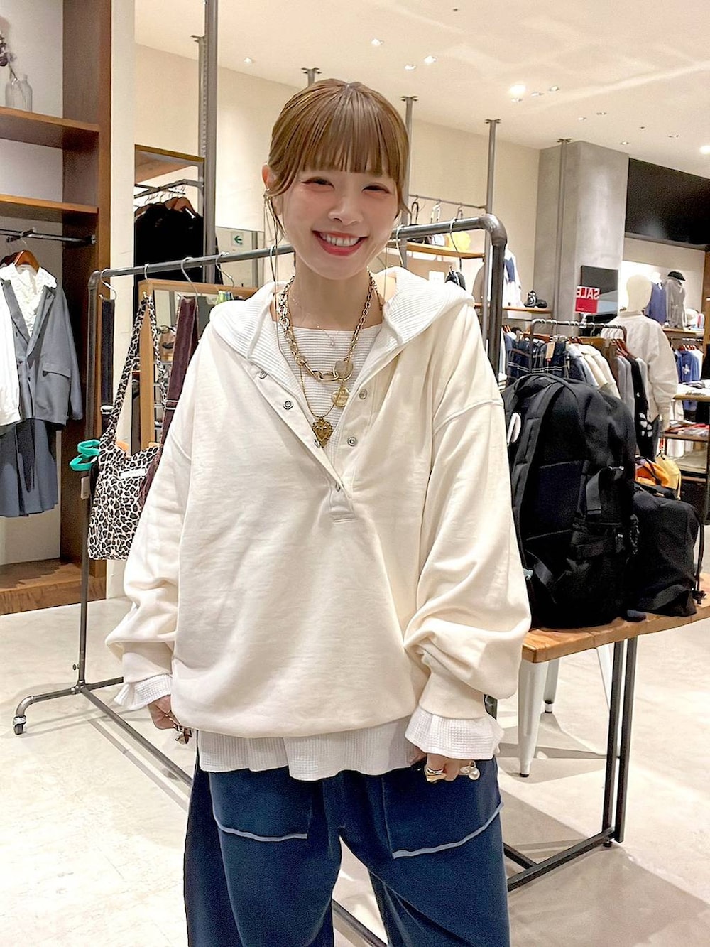 ベージュ系のショルダーバッグ、ホワイト系のパーカー、ホワイト系のTシャツ/カットソーを着用したレディースの冬コーディネートの2枚目の写真