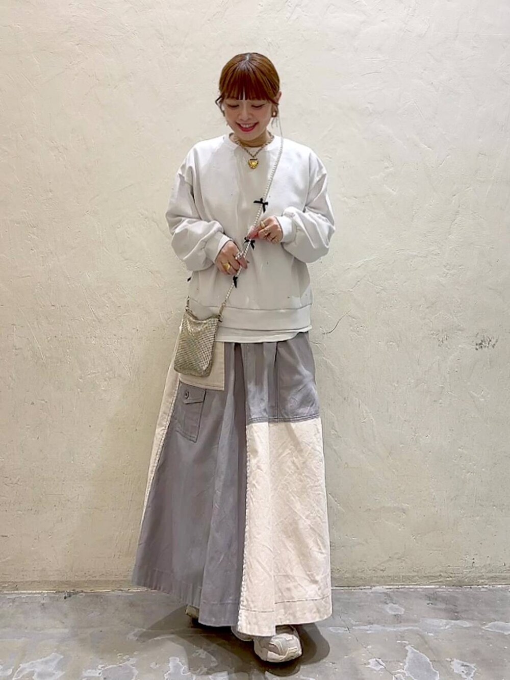 ゴールド系のショルダーバッグ、ホワイト系のTシャツ/カットソー、ホワイト系のその他トップスを着用したレディースの冬コーディネートの3枚目の写真