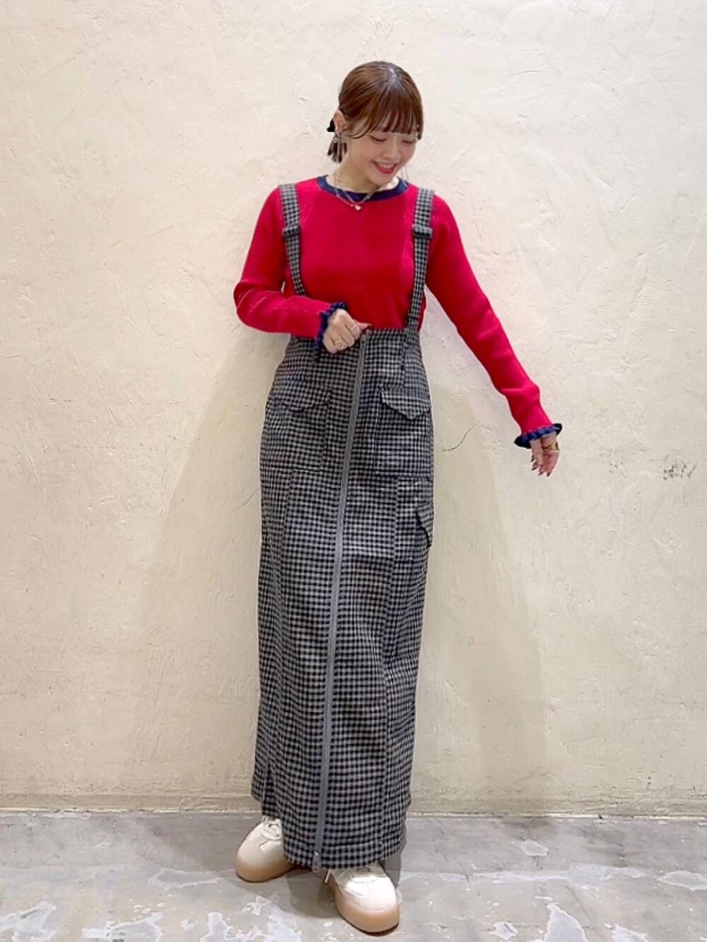 ブラック系のスカート、レッド系のニット/セーターを着用したレディースの秋コーディネートの6枚目の写真