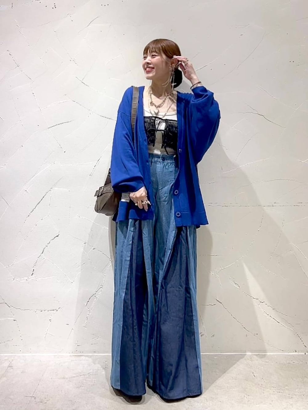 ブラック系のキャミソール、ブラウン系のショルダーバッグを着用したレディースの秋コーディネートの2枚目の写真