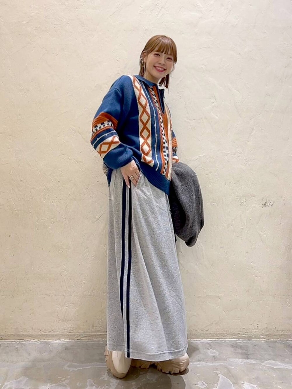 ブルー系のニット/セーター、グレー系のストール/ショール、ブラック系のバレッタ/ヘアクリップを着用したレディースの秋コーディネートの3枚目の写真