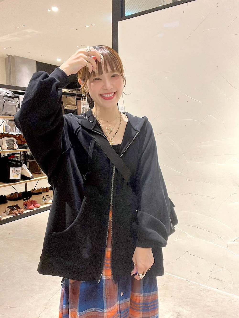 ブラック系のショルダーバッグ、イエロー系のネックレスを着用したレディースの秋コーディネートの2枚目の写真