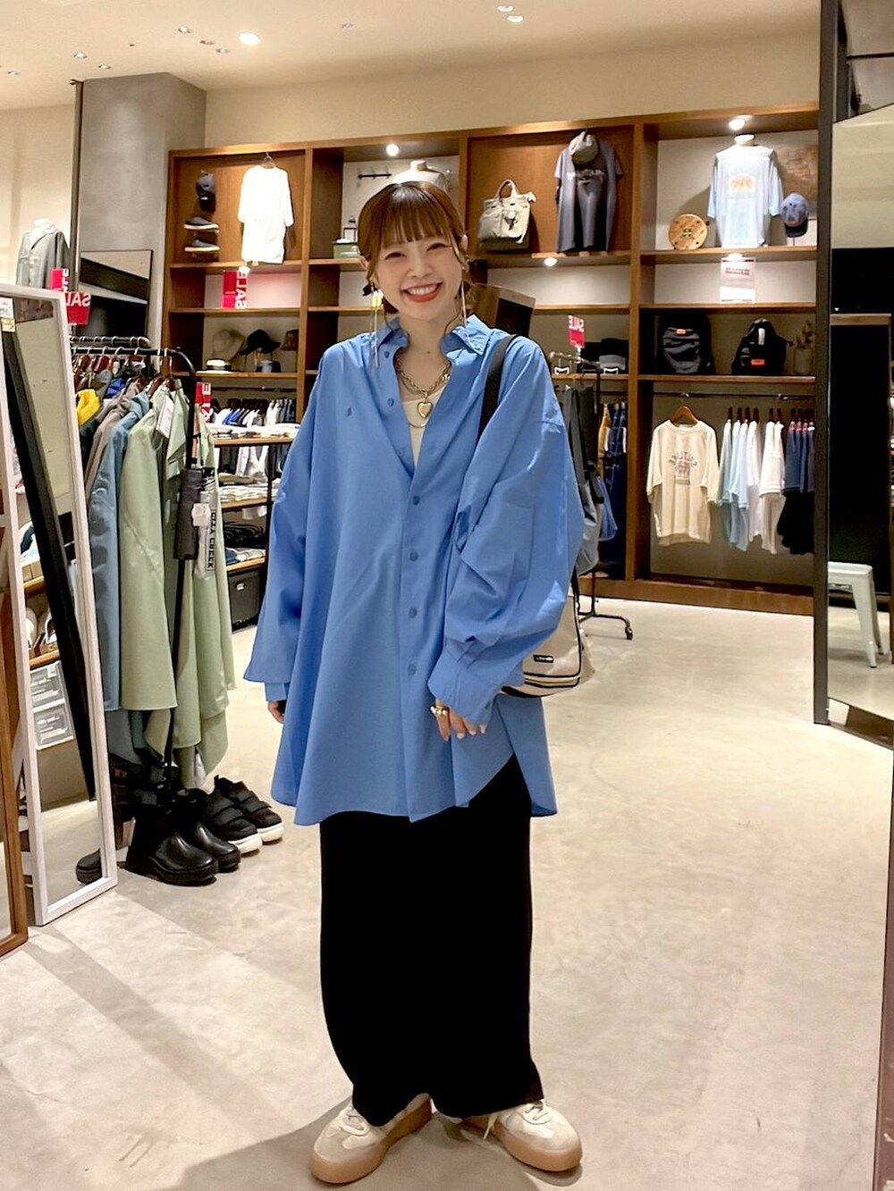 ブラック系のスカート、ブルー系のシャツ/ブラウス、ベージュ系のショルダーバッグを着用したレディースの夏コーディネートの3枚目の写真