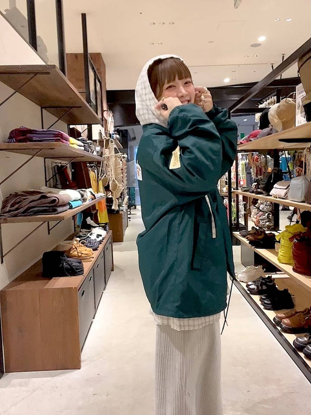 グレー系のスカート、ベージュ系のシャツ/ブラウス、グリーン系のナイロンジャケットを着用したレディースの冬コーディネートの7枚目の写真