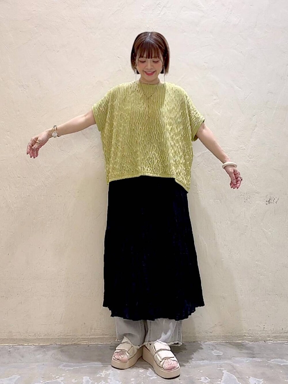 ホワイト系のサンダル、ブラック系のスカート、グレー系のデニムパンツを着用したレディースの夏コーディネートの6枚目の写真