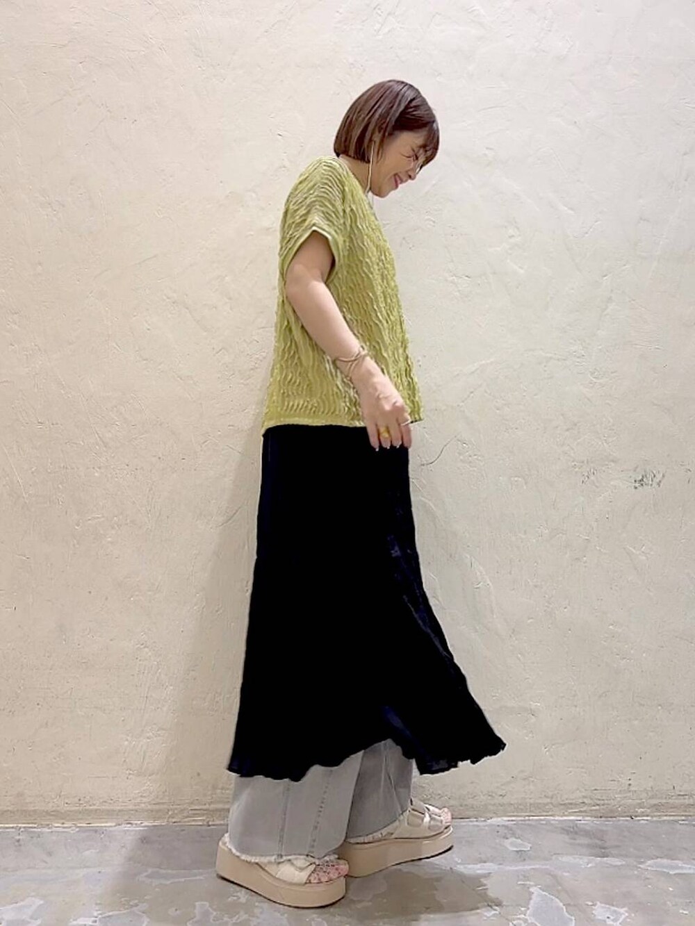 ホワイト系のサンダル、ブラック系のスカート、グレー系のデニムパンツを着用したレディースの夏コーディネートの3枚目の写真