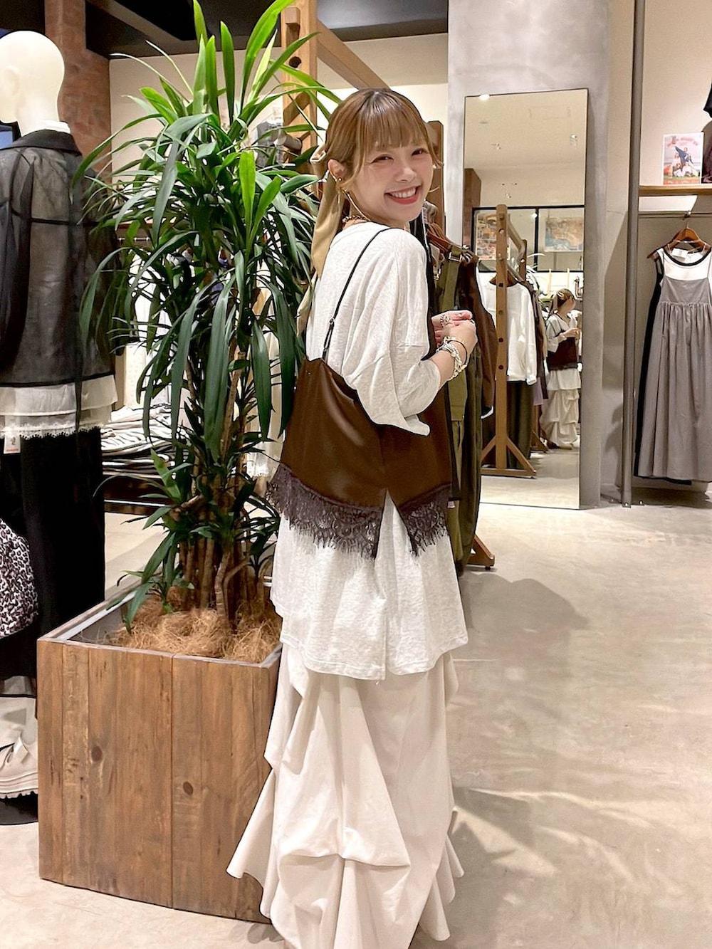 ホワイト系のタンクトップ、ベージュ系のスカート、ブラウン系のキャミソールを着用したレディースの夏コーディネートの4枚目の写真