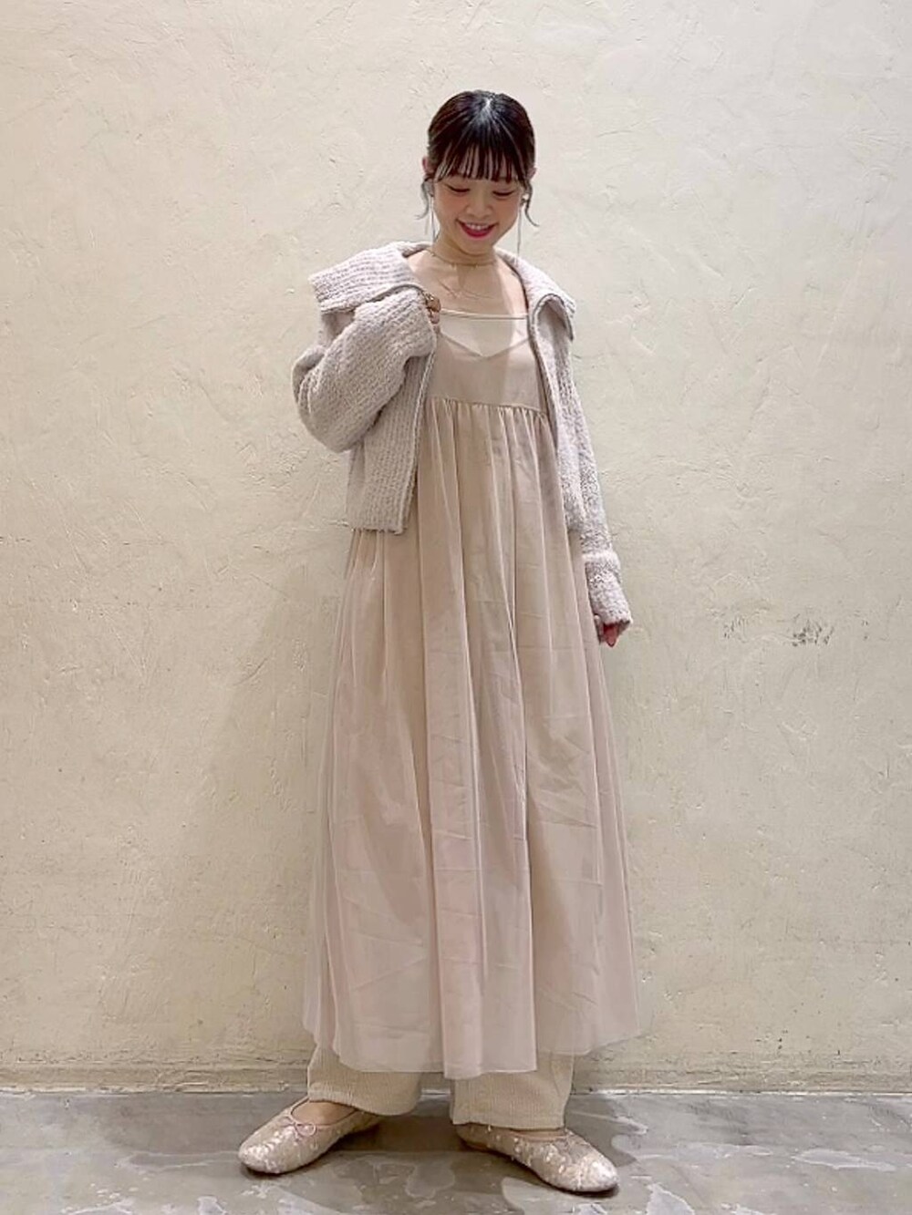 ベージュ系のワンピース、ホワイト系のその他パンツ、ホワイト系のバレエシューズを着用したレディースの冬コーディネートの7枚目の写真