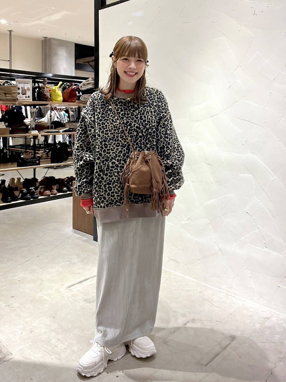 レッド系のTシャツ/カットソー、グレー系のスカート、ベージュ系のスニーカーを着用したレディースの冬コーディネートの3枚目の写真