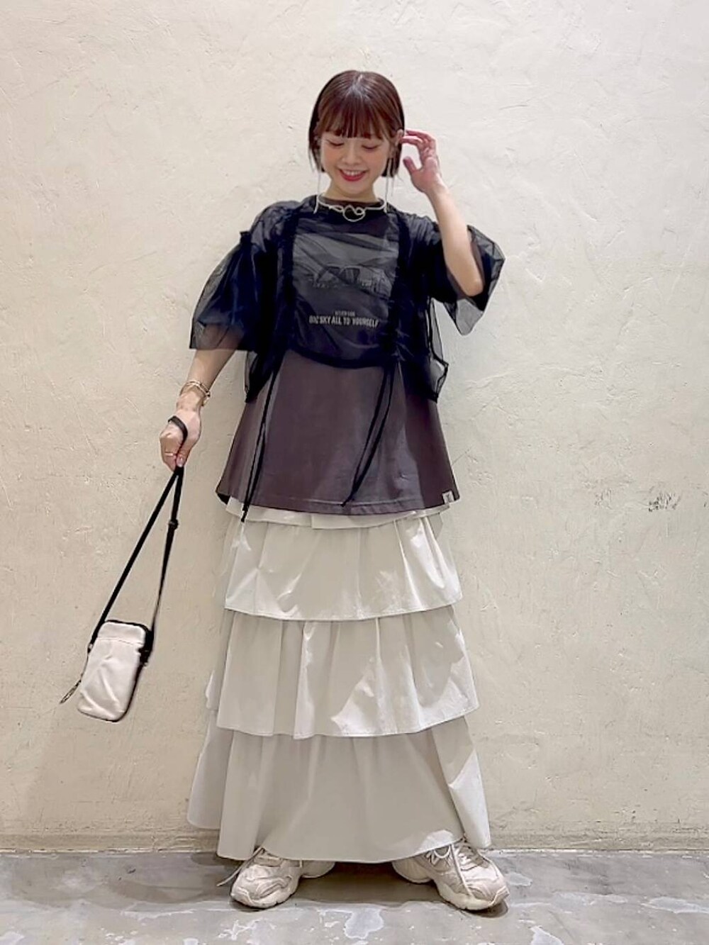 ブラック系のその他トップス、その他のTシャツ/カットソー、ベージュ系のショルダーバッグを着用したレディースの春コーディネートの2枚目の写真