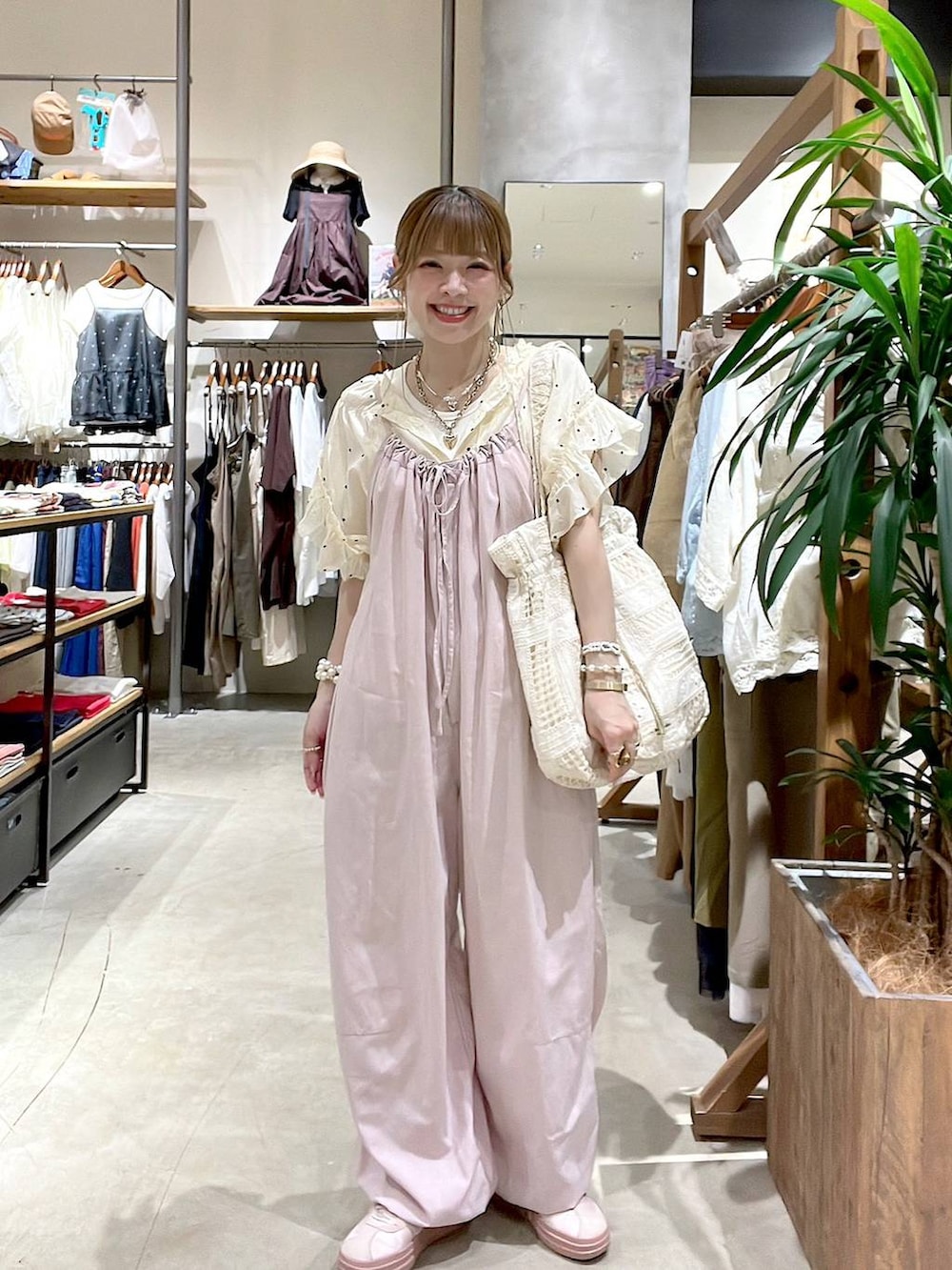 ピンク系のサロペット/オーバーオール、ベージュ系のトートバッグ、ホワイト系のシャツ/ブラウスを着用したレディースの夏コーディネートの6枚目の写真