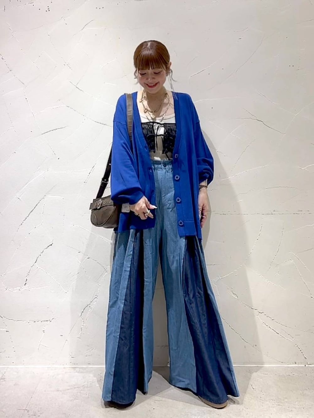 ブラック系のキャミソール、ブラウン系のショルダーバッグを着用したレディースの秋コーディネートの9枚目の写真