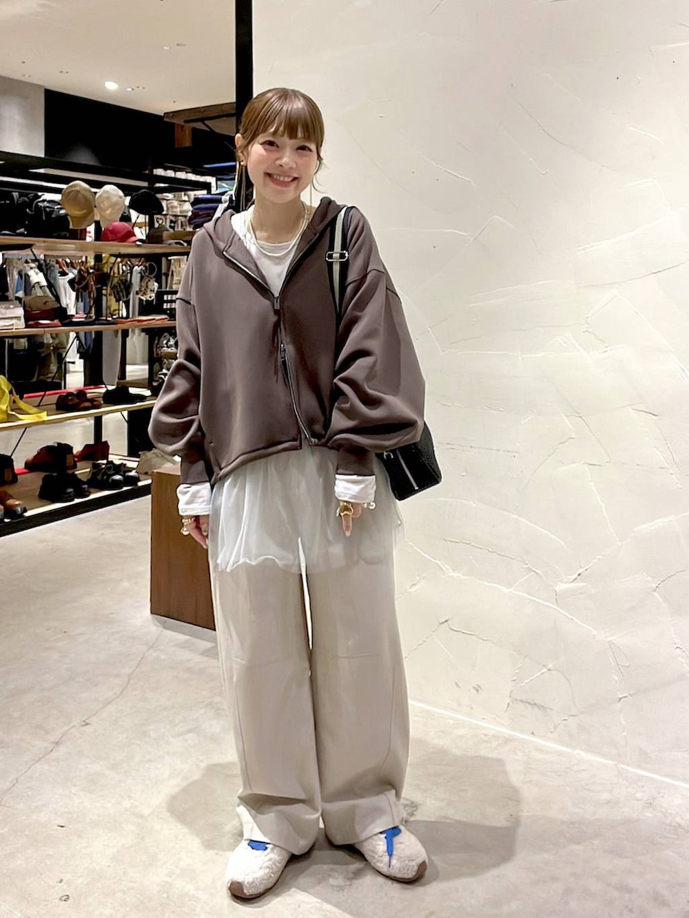 ブラック系のショルダーバッグ、ベージュ系のスニーカー、ベージュ系のその他パンツを着用したレディースの冬コーディネートの3枚目の写真