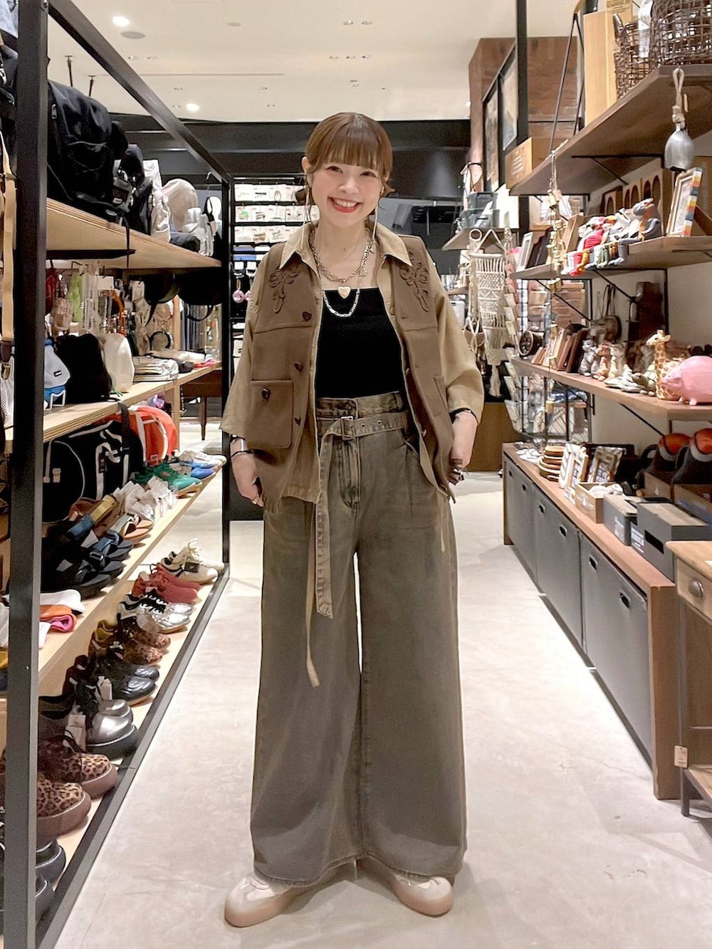 ベージュ系のシャツ/ブラウス、ブラウン系のデニムパンツ、イエロー系のベストを着用したレディースの夏コーディネートの2枚目の写真