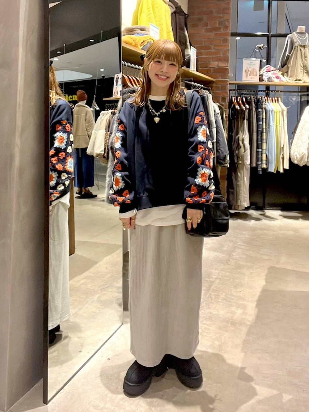 ブルー系のスウェット、ホワイト系のTシャツ/カットソー、グレー系のスカートを着用したレディースの冬コーディネートの3枚目の写真