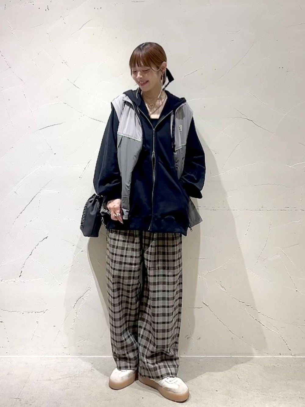 ブラック系のショルダーバッグ、ブラウン系のその他パンツ、イエロー系のネックレスを着用したレディースの秋コーディネートの2枚目の写真