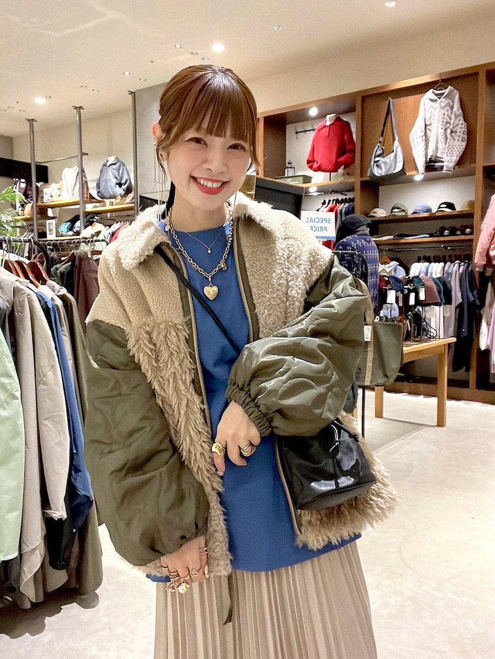 ブルー系のTシャツ/カットソー、ベージュ系のスカート、ベージュ系のブルゾンを着用したレディースの秋コーディネートの6枚目の写真